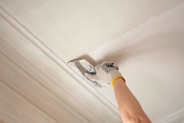 Plasterer applying plaster to a ceiling in a Dublin home